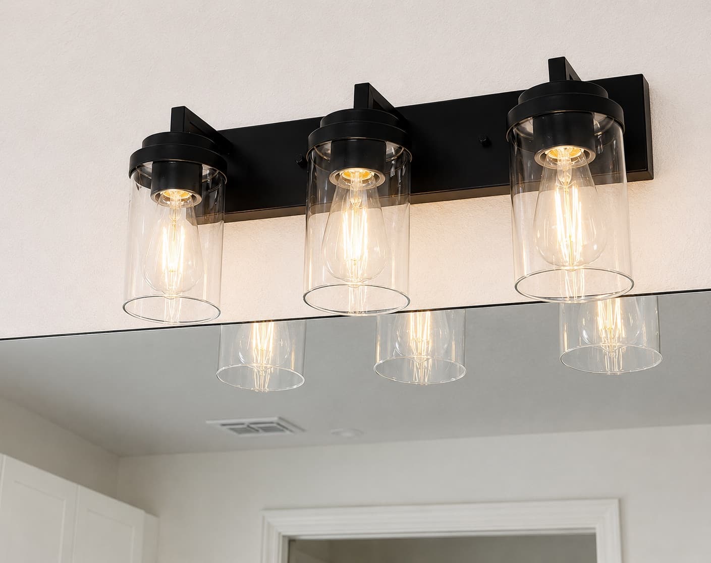 Three-light vanity fixture installed above a bathroom mirror in a Central Florida home
